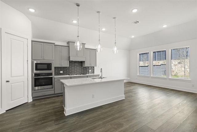 kitchen with lofted ceiling, stainless steel oven, dark hardwood / wood-style floors, and gray cabinets