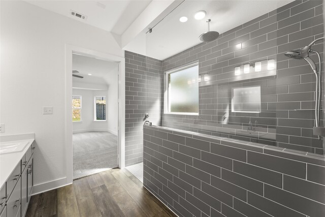 bathroom featuring walk in shower, hardwood / wood-style flooring, and vanity