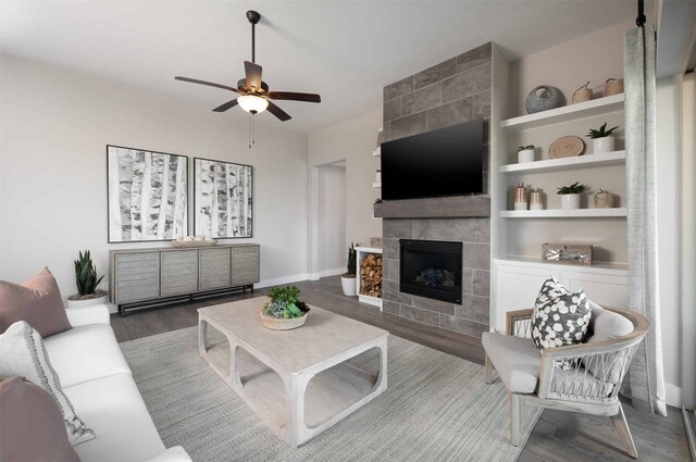 living room featuring ceiling fan, a tiled fireplace, hardwood / wood-style floors, and built in features