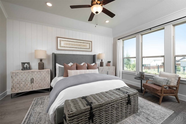 bedroom with dark wood-type flooring, wooden walls, multiple windows, and ceiling fan