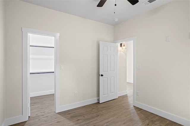 727 W Parnell St, Denison, TX 75020 - unfurnished bedroom with wood finished floors, baseboards, a spacious closet, a closet, and a ceiling fan