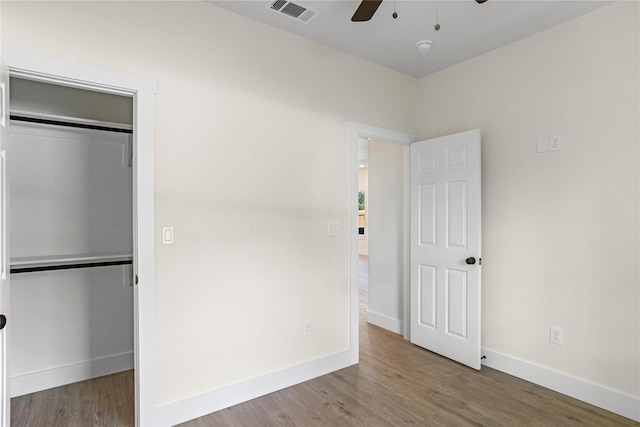 unfurnished bedroom with a closet, hardwood / wood-style flooring, and ceiling fan