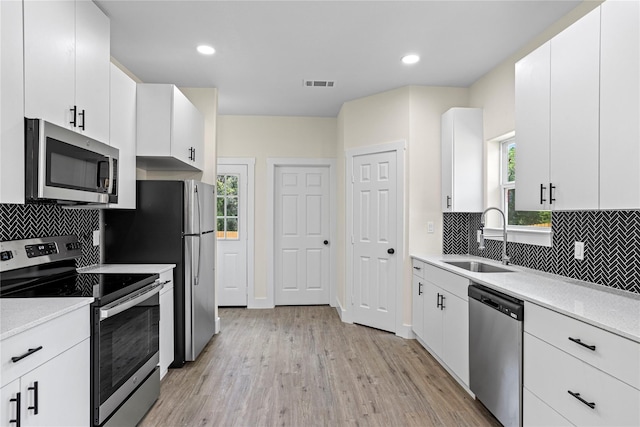 727 W Parnell St, Denison, TX 75020 - kitchen featuring appliances with stainless steel finishes, a sink, healthy amount of natural light, light wood-style floors, and recessed lighting