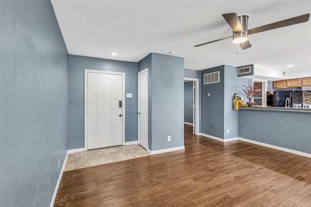 foyer featuring ceiling fan and light wood-type flooring