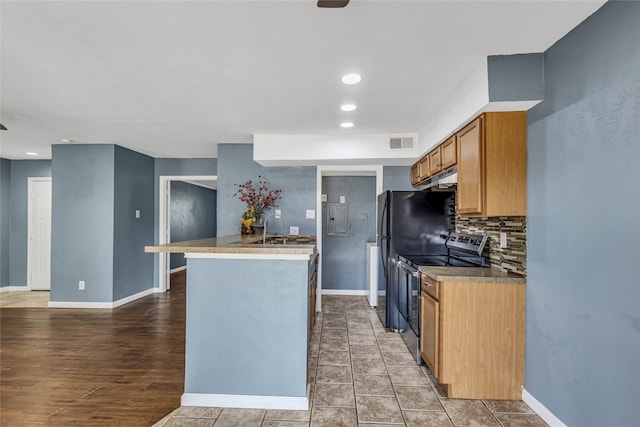 kitchen featuring electric range, sink, and backsplash