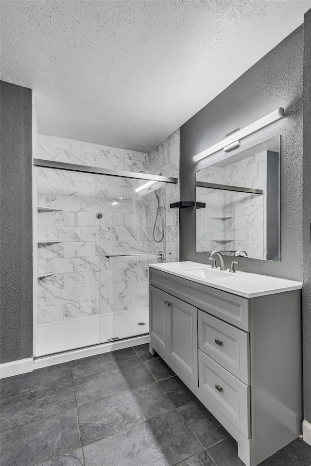 bathroom with vanity, a textured ceiling, and walk in shower