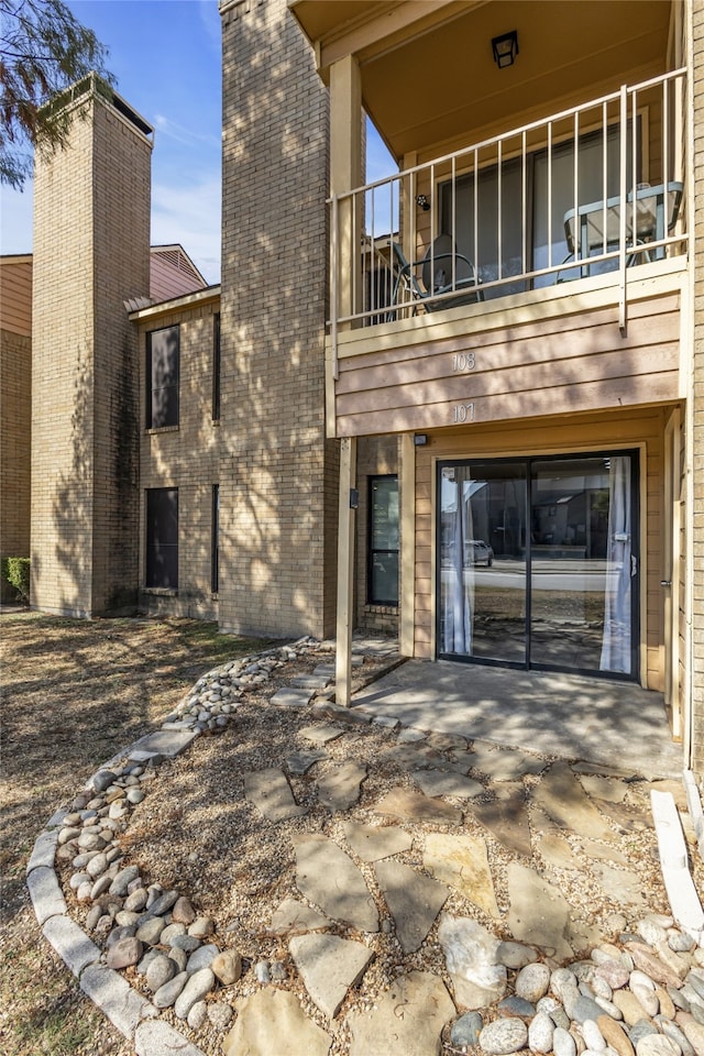 back of house with a balcony and a patio