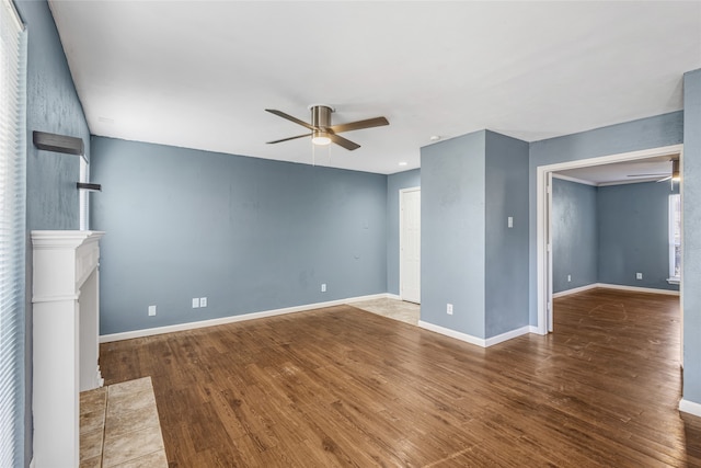 unfurnished living room featuring a tile fireplace, ceiling fan, and hardwood / wood-style flooring