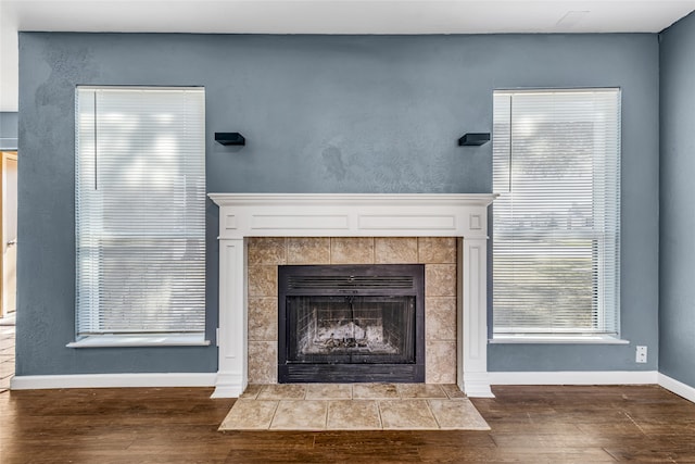 interior details featuring wood-type flooring and a tile fireplace