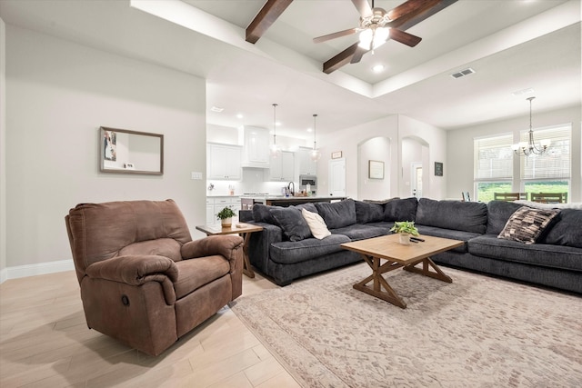 living room featuring beam ceiling, sink, and ceiling fan with notable chandelier