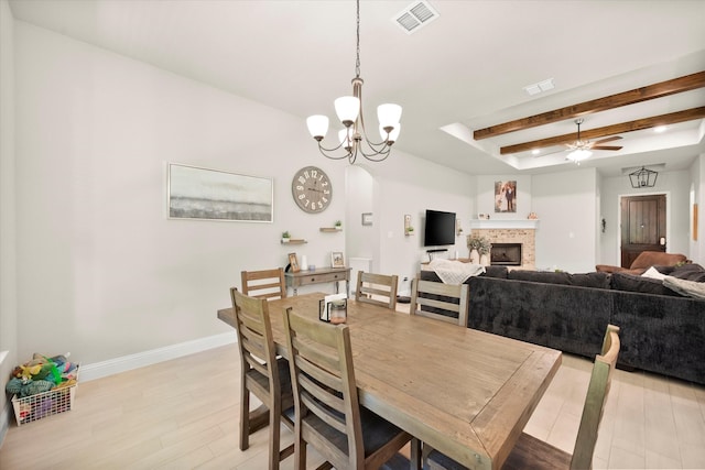 dining room with light hardwood / wood-style floors, beam ceiling, and ceiling fan with notable chandelier