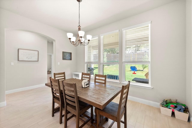 dining space with light hardwood / wood-style flooring and an inviting chandelier