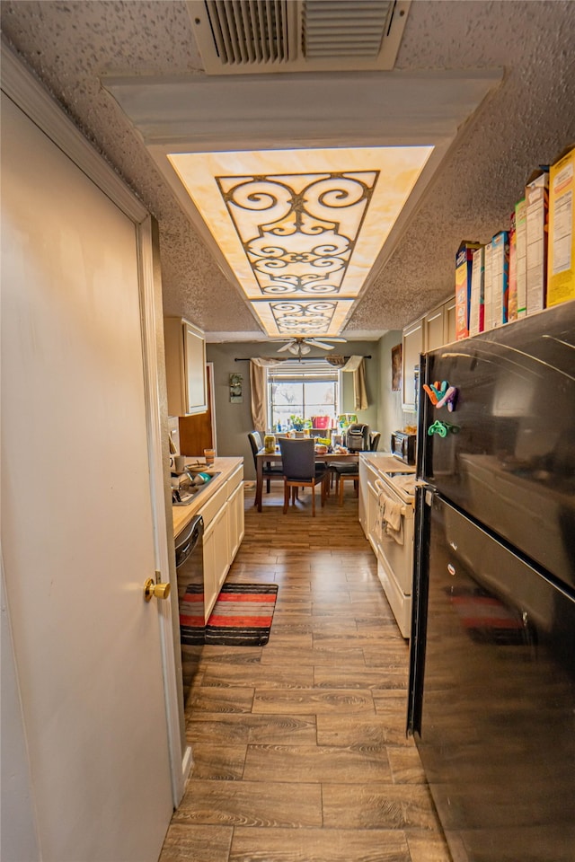 interior space with a textured ceiling and light hardwood / wood-style flooring