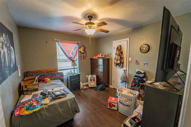 bedroom featuring dark wood-type flooring, a textured ceiling, and ceiling fan