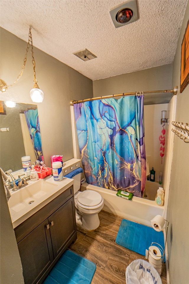 full bathroom featuring vanity, wood-type flooring, a textured ceiling, shower / tub combo, and toilet