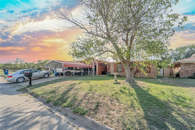 ranch-style home with a lawn and a carport