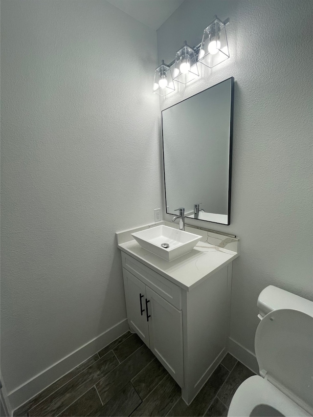 bathroom with vanity, toilet, and wood-type flooring