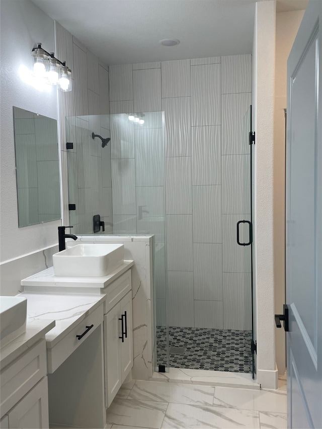 bathroom with a shower with shower door and vanity