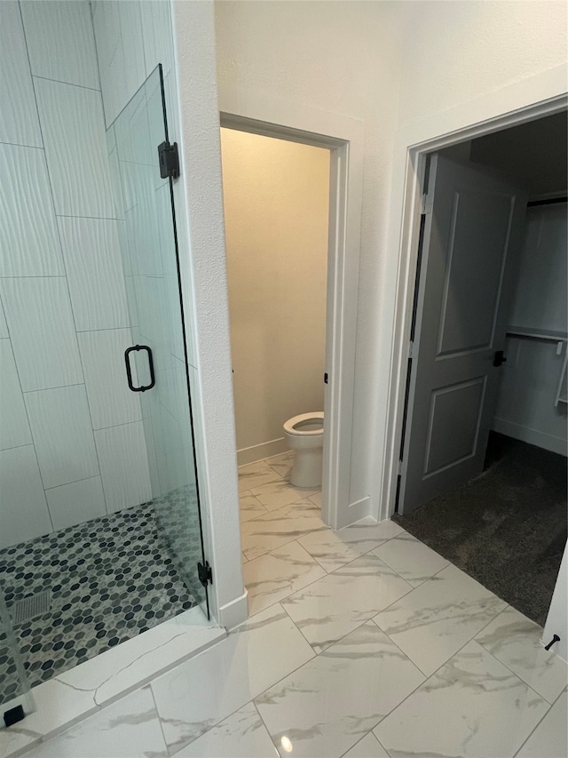 bathroom with toilet and a shower with shower door