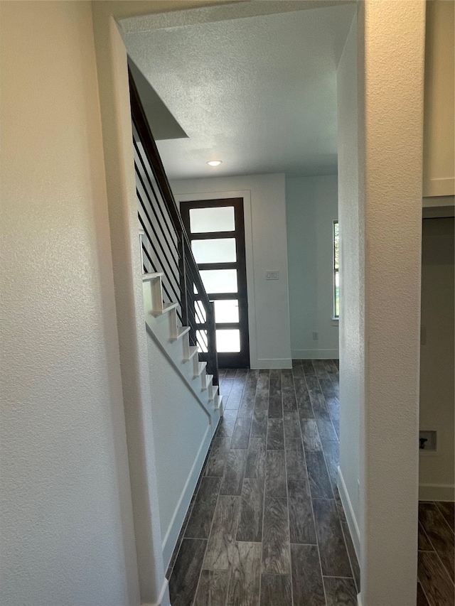 entryway featuring dark wood-type flooring and a textured ceiling