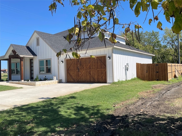 view of side of property with a garage and a lawn