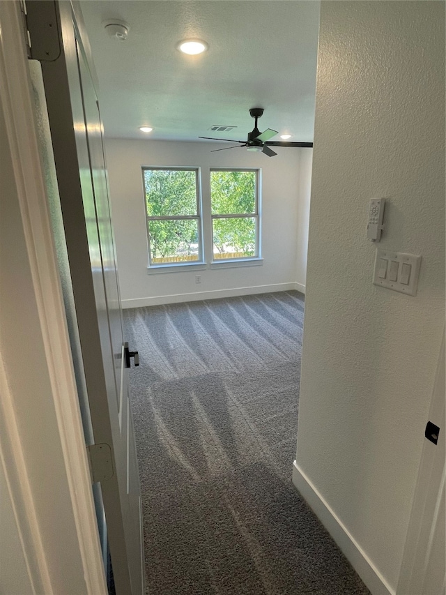 empty room featuring ceiling fan and carpet flooring