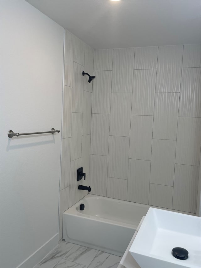 bathroom with sink and tiled shower / bath combo