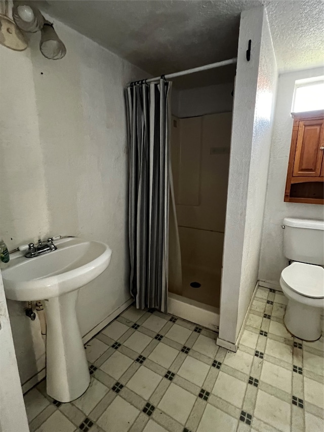 bathroom featuring sink, toilet, and a shower with shower curtain