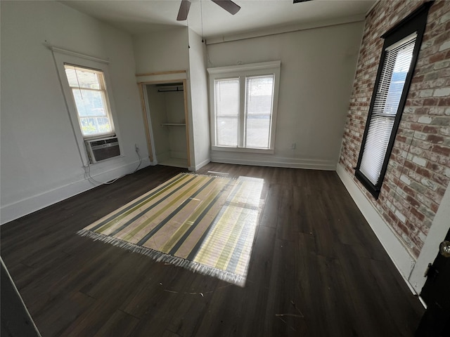 interior space featuring ceiling fan, cooling unit, dark hardwood / wood-style floors, and multiple windows