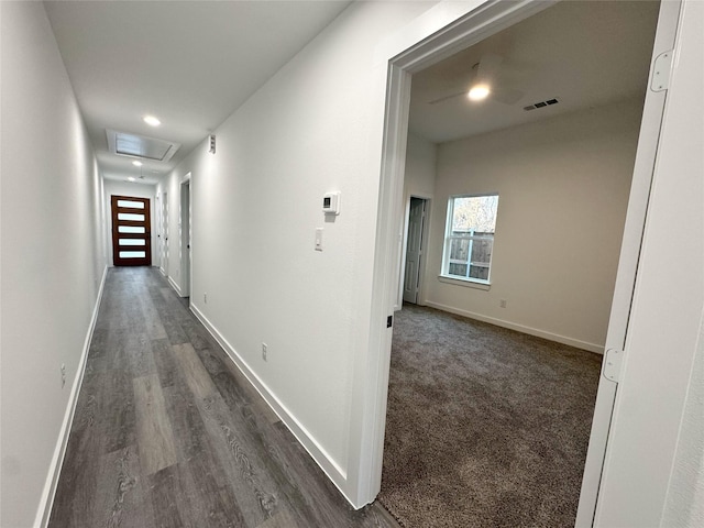 corridor featuring dark colored carpet