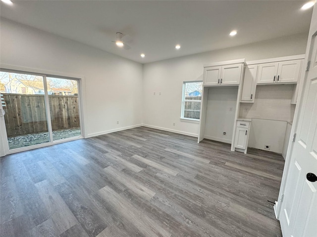 kitchen featuring tasteful backsplash, wood-type flooring, a wealth of natural light, and white cabinetry