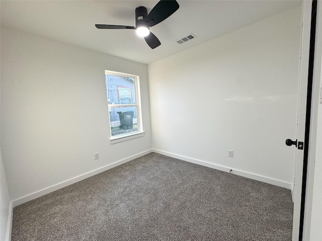 empty room with ceiling fan and dark carpet