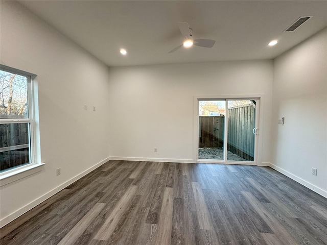 unfurnished room with ceiling fan, a healthy amount of sunlight, and dark wood-type flooring