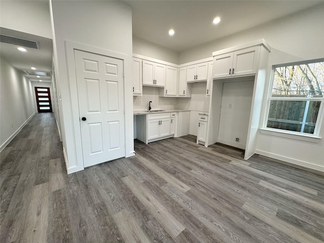 kitchen featuring dark wood-type flooring, sink, and white cabinetry