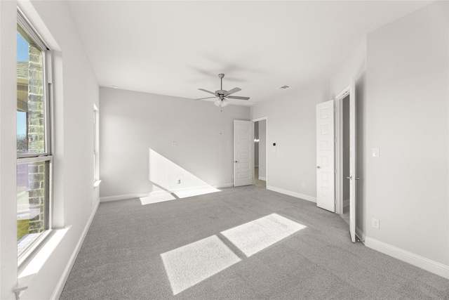 carpeted empty room featuring plenty of natural light and ceiling fan