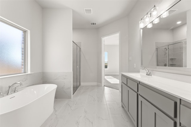 bathroom with separate shower and tub, a wealth of natural light, and vanity