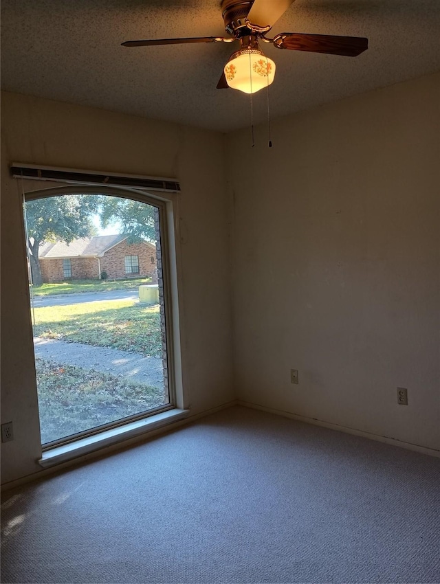 unfurnished room with carpet flooring, a textured ceiling, and ceiling fan