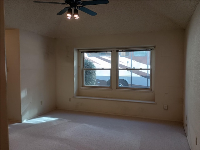 carpeted spare room with a textured ceiling and ceiling fan