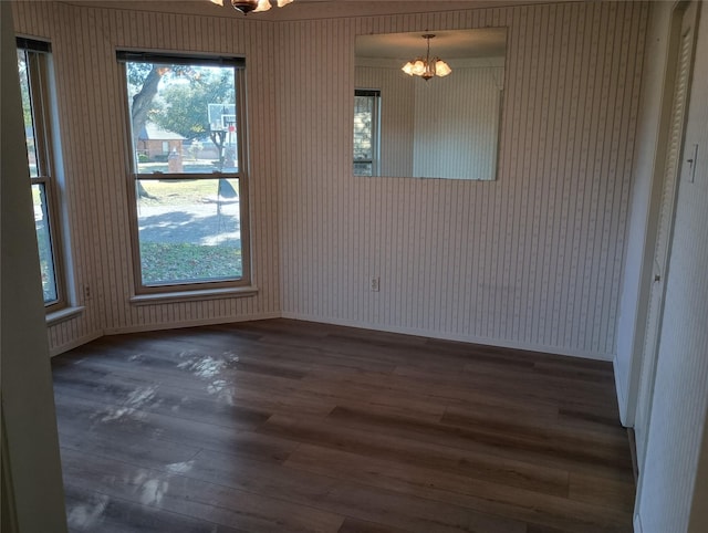 unfurnished dining area with dark wood-type flooring and a chandelier