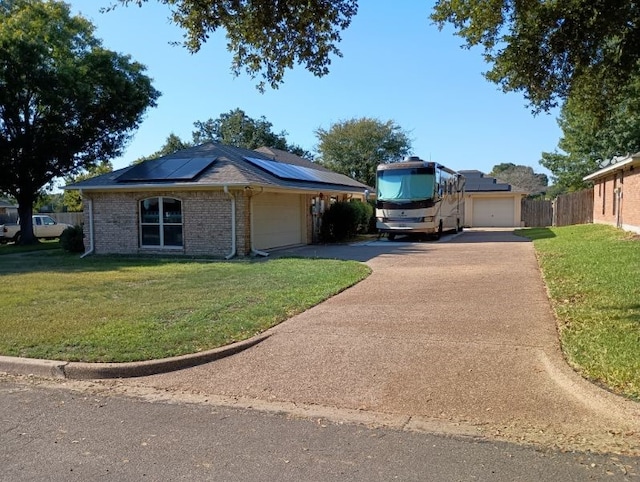 ranch-style home featuring solar panels, a garage, and a front lawn