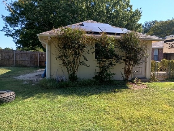 view of home's exterior featuring a lawn and solar panels