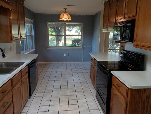 kitchen featuring pendant lighting, light tile patterned floors, black appliances, and sink