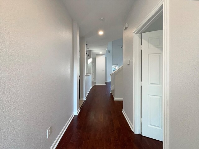 hall featuring baseboards, wood finished floors, and recessed lighting