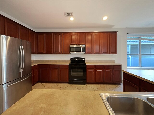 kitchen with stainless steel appliances, light countertops, visible vents, and a sink