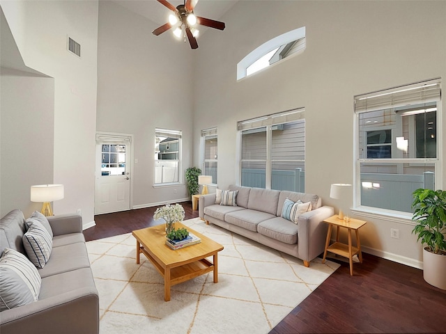 living room featuring high vaulted ceiling, a ceiling fan, visible vents, and light wood-type flooring