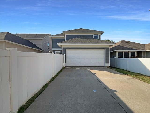 garage featuring fence and driveway