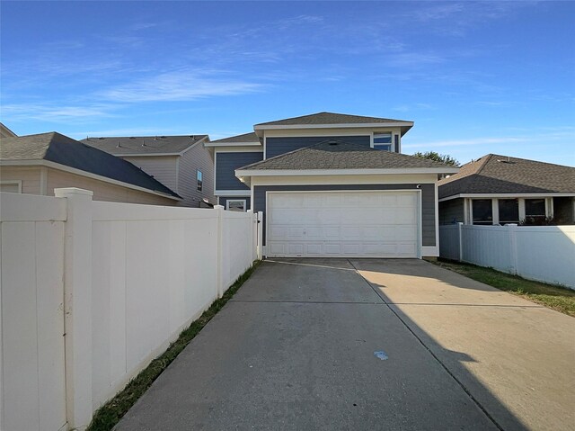 exterior space featuring an attached garage, driveway, and fence