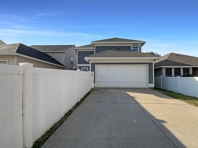 view of home's exterior with an attached garage, driveway, and fence