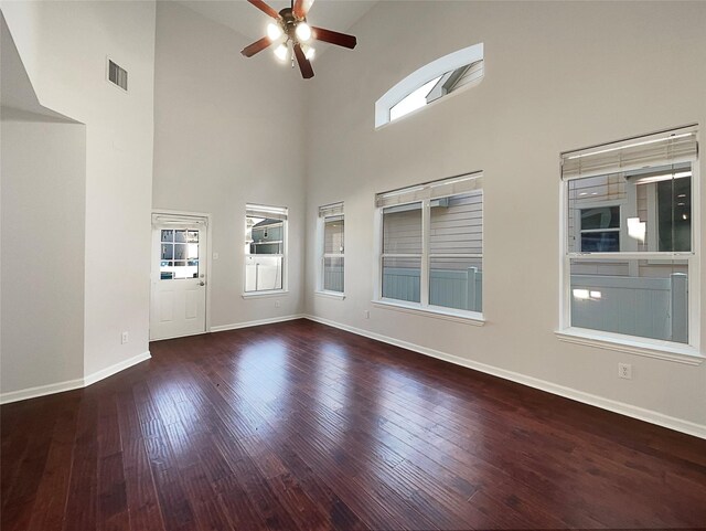 interior space featuring baseboards, visible vents, ceiling fan, hardwood / wood-style flooring, and high vaulted ceiling