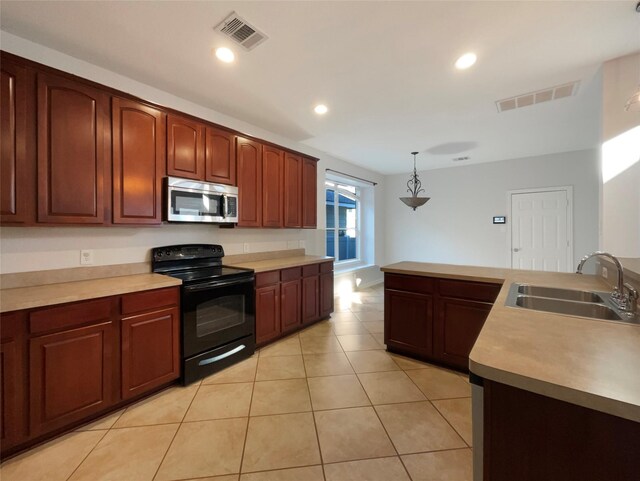 kitchen with visible vents, a sink, stainless steel microwave, and electric range